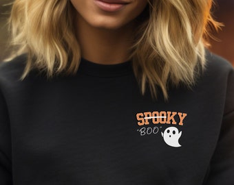 May include: Black sweatshirt with the text "Spooky Boo" and a ghost graphic in white. The text is in orange and white. The sweatshirt is a crew neck style.