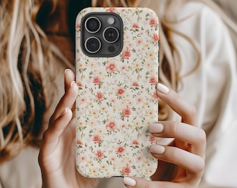 Könnte beinhalten: Eine weiße iPhone-Hülle mit einem Blumenmuster mit rosa und gelben Blumen. Die Hülle hat einen Ausschnitt für das Kameraobjektiv.