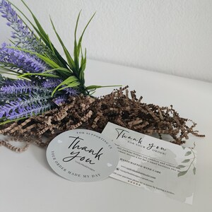 May include: An arrangement featuring purple lavender, green foliage, and brown paper filler. Includes two thank you cards and a round sticker with the text "Thank You" and "Your order made my day."