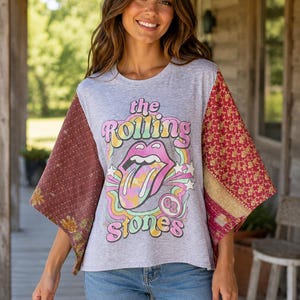 May include: A heather gray short-sleeve t-shirt featuring a graphic of The Rolling Stones logo with the text 'the Rolling Stones' and '62'. The shirt has wide, contrasting sleeves made of patterned maroon and gold fabric with a visible stitched texture.