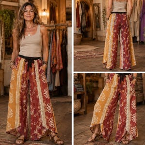 May include: Wide-leg pants featuring a vertical patchwork design in shades of deep red, mustard yellow, and cream. The pants have a high-rise waist with a black tie-front closure, side pockets, and a loose, flowing silhouette with patterned panels.