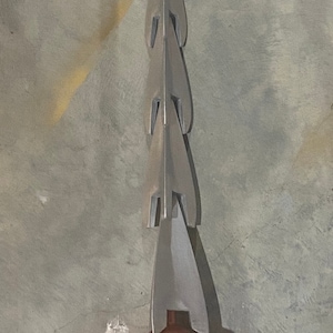 以下が含まれることがあります： 銅色のハンドルが付いた、銀色の多岐にわたる槍。槍は先のとがった先端と、その全長にわたって鋭い突起が並んでいます。