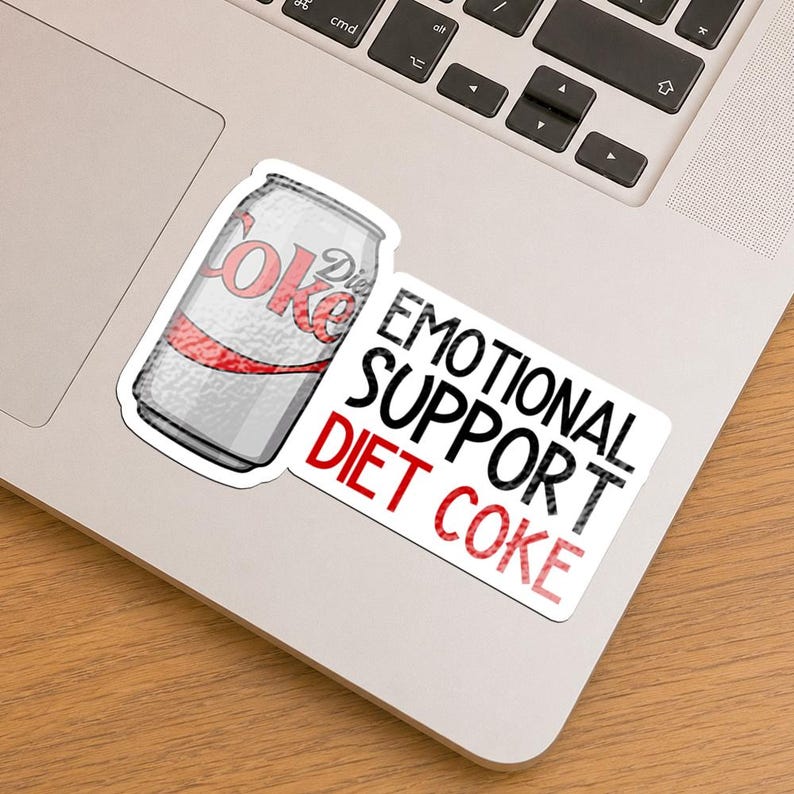 May include: A sticker featuring a silver Diet Coke soda can illustration next to the black and red text that reads EMOTIONAL SUPPORT DIET COKE. The design is printed on a white background with a die-cut border, showcasing a metallic texture.