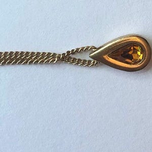 Vintage circa 1970s Avon marked teardrop pendant necklace. Available in topaz color.
