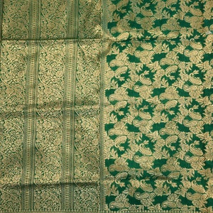 May include: A green and gold patterned fabric with a paisley design. The fabric has a subtle sheen and is woven with intricate details.