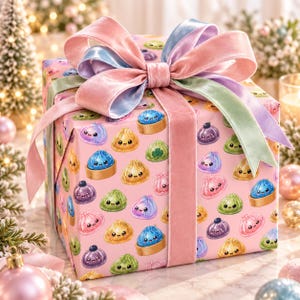 Könnte beinhalten: Ein quadratisches Geschenkpaket in hellrosa Papier mit einem wiederkehrenden Muster aus bunten, lächelnden Cartoon-Teigtaschen. Das Paket ist mit einer großen, mehrlagigen Samtschleife in Pastelltönen wie Rosa, Hellblau und Salbeigrün verziert.
