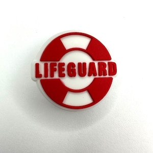May include: Red and white lifeguard charm with the word "LIFEGUARD" in red letters.