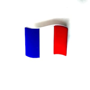 May include: A curved emblem of the French flag, with vertical stripes in blue, white, and red. The design is set against a white background, with a slightly curved shape.