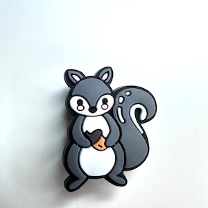 May include: A gray cartoon squirrel with pink cheeks holding a brown acorn. The squirrel has a white belly and a gray tail.