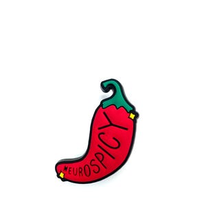 Puede incluir: Un dije en forma de chile rojo con el texto "NEUROSPICY" en negro. El dije tiene un tallo verde y peque&ntilde;os detalles amarillos. El dise&ntilde;o est&aacute; sobre un fondo blanco.