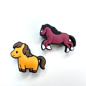 May include: Two cartoon horse figurines. One is brown and the other is yellow.
