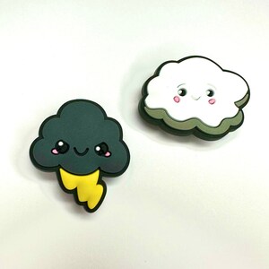 May include: Two cartoon clouds with smiling faces. One cloud is white and the other is dark gray with a yellow lightning bolt.