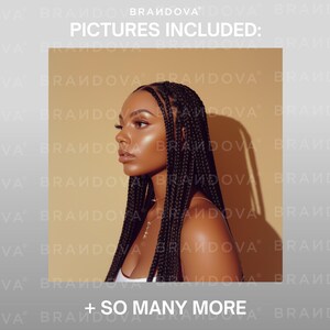 May include: A woman with dark skin and long black braids looks to the side. She is wearing a white tank top and a gold necklace. The background is a light brown color.