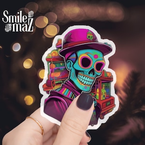 May include: A colorful sticker featuring a stylized skull wearing a pink hat with a small green skull emblem. The skull has vibrant turquoise skin and is adorned with neon-colored details. The sticker has the text "Smile maz" in the upper left corner.