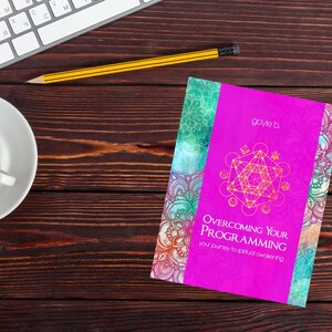 May include: A pink book with a gold geometric design on the cover. The title of the book is "Overcoming Your Programming: Your Journey to Spiritual Awakening." The author's name is "gayle b."