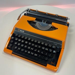 Máquina de escribir portátil vintage Welco S100, máquina de escribir ligera, color naranja vibrante, retro, de 1979, totalmente funcional y en buen estado de funcionamiento.
