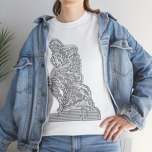 Peut inclure: Un t-shirt blanc avec un motif noir et blanc de la statue du Penseur, conçu pour ressembler à un circuit imprimé.