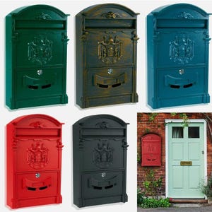 May include: A set of six mailboxes in different colours, including green, blue, red, black, brown, and gold. Each mailbox features a decorative design with a crest and two compartments. The mailboxes are made of metal and have a vintage look.