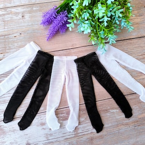 Puede incluir: Cuatro pares de medias para muñecas, dos negras y dos blancas. Las medias son transparentes y tienen un delicado encaje en la parte superior.