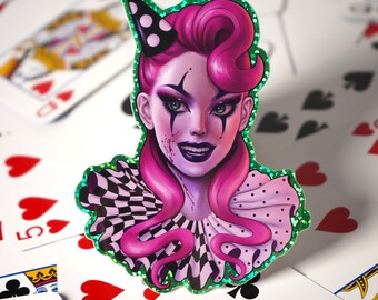 Könnte beinhalten: Ein Aufkleber mit einem pinkhaarigen Clown mit einem schwarz-weiß karierten Kragen und einem grünen Glitzerhintergrund. Der Clown hat ein unheimliches Lächeln und ein schwarzes Auge.