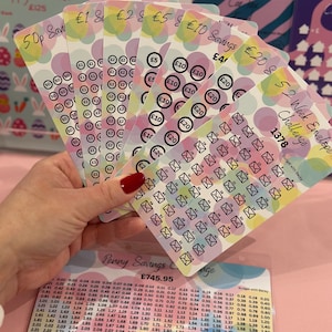 May include: A set of colourful envelopes with a savings challenge theme. The envelopes are labelled with amounts from 50 pence to £20. The envelopes are designed with a pink, blue, and yellow watercolour background with white polka dots. The envelopes are part of a 52-week savings challenge.