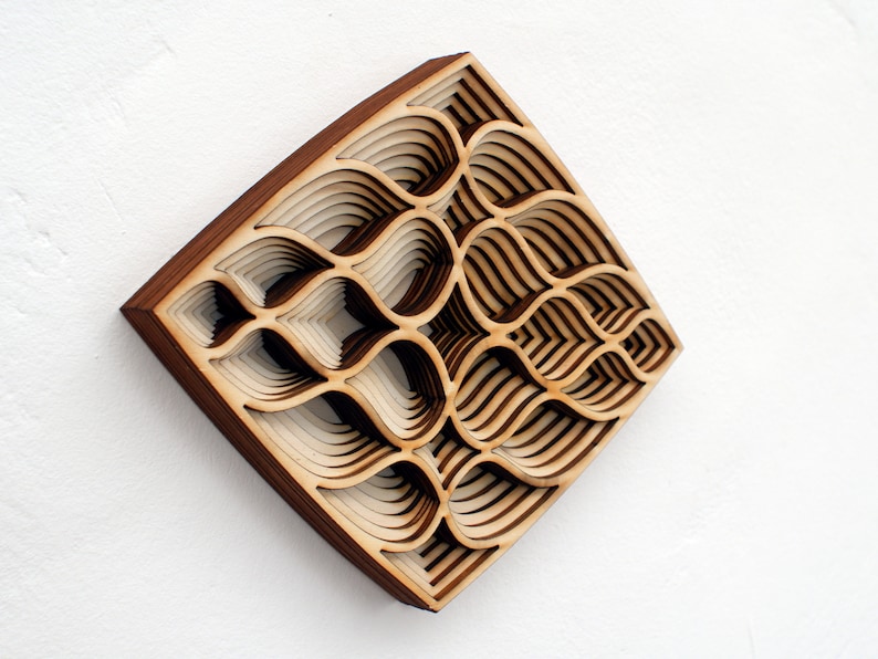 May include: A wooden wall art piece with a geometric pattern of overlapping layers. The piece is made of light and dark wood and has a square shape.
