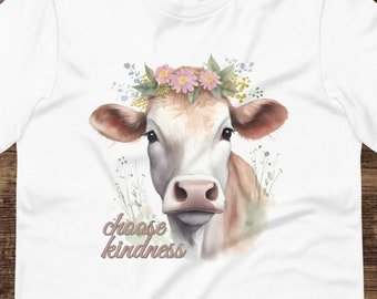Op de afbeelding: Wit T-shirt met een aquarel-illustratie van een koe die een bloemenkrans draagt. De tekst "choose kindness" is onder de koe gedrukt.