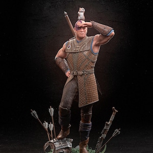 May include: A detailed figurine of a bald, muscular man wearing a brown leather tunic and holding a sword. He has a blue eye patch and a small white animal is perched on his head. The figurine is standing on a rocky base with green plants and arrows.