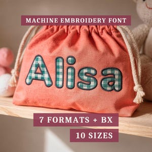以下が含まれることがあります： 緑と白のギンガムチェック柄でAlisaという名前が刺繍されたコーラルカラーの巾着袋。画像にはMACHINE EMBROIDERY FONT、7 FORMATS + BX、10 SIZESというテキストが濃い赤色のバナーで重ねて表示されています。
