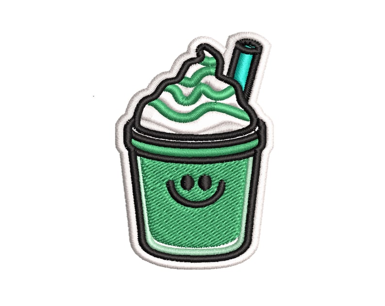 K&ouml;nnte beinhalten: Gr&uuml;ne und wei&szlig;e gestickte Applikation eines l&auml;chelnden gr&uuml;nen Smoothies mit Schlagsahne und einem blauen Strohhalm.