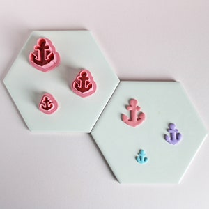 May include: Set of six anchor-shaped cookie cutters in various sizes. The cutters are pink, purple, and blue.