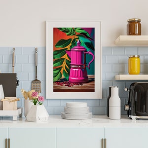 May include: A framed art print featuring a vibrant pink coffee maker with a green handle, set against a backdrop of lush green leaves and a colorful background. Scattered coffee beans add detail. The artwork is displayed in a kitchen setting.