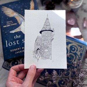 Peut inclure: Un dessin au trait noir et blanc d'une tour de pierre avec un toit pointu. La tour a une petite fenêtre et une porte. Un petit arbre pousse à côté de la tour.