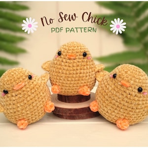 Puede incluir: Tres juguetes de pollito amarillos tejidos a crochet con picos y patas naranjas. Los pollitos están sentados sobre una superficie de madera. El texto "No Sew Chick PDF PATTERN" está por encima de los pollitos.
