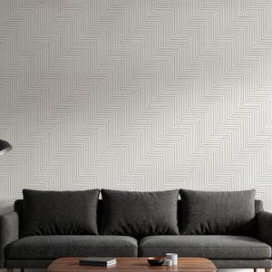 Könnte beinhalten: Ein modernes Wohnzimmer mit einem dunkelgrauen Sofa mit drei Kissen, einem Couchtisch aus Holz und einer Wand mit einem geometrischen Zickzackmuster. Das Wandmuster ist weiß mit dünnen grauen Linien.