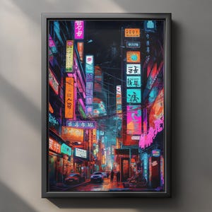 Puede incluir: Impresión artística enmarcada que representa una vibrante escena callejera iluminada con neones en una ciudad japonesa por la noche. La obra presenta letreros coloridos, edificios y vehículos, con un fondo oscuro. La impresión está en un marco negro.