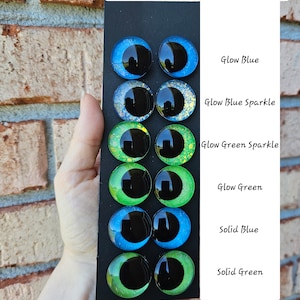 Peut inclure: Un ensemble de dix yeux en plastique qui brillent dans le noir pour l'artisanat. Les yeux sont disposés par paires, chaque paire représentant une couleur différente : bleu fluorescent, bleu fluorescent pailleté, vert fluorescent pailleté, vert fluorescent, bleu uni et vert uni.