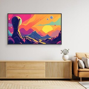 May include: A rectangular wall art print featuring a vibrant, stylized landscape with a large, dark, abstract monolith in the foreground, rolling mountains, a winding river, and a bright yellow sun set against a colorful, multi-hued sky.