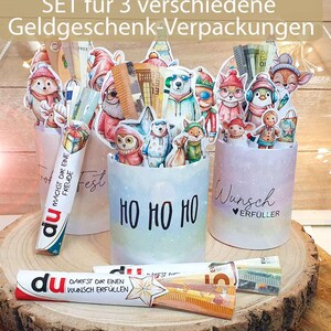 Drei gebastelte Duplo-Schachteln, dekoriert als Geldgeschenk zu Weihnachten mit Banderolen im Aquarell-Stil.