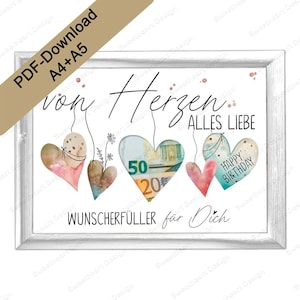 May include: A white frame with a white background and a message that reads "von Herzen... Alles Liebe" with four watercolor hearts hanging from the top. The hearts are filled with money and one says "Happy Birthday". The text below the hearts reads "Wunscherfüller für Dich".