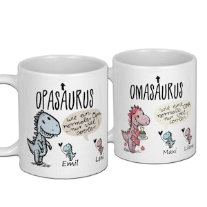 Könnte beinhalten: Zwei weiße Keramikbecher mit einem Dinosaurier-Design. Der Becher links sagt "OPASAURUS" mit einem blauen Dinosaurier und dem Text "wie ein normaler Opa...nur viel cooler!"  Der Becher rechts sagt "OMASAURUS" mit einem rosa Dinosaurier und dem Text "wie eine normale Oma...nur viel cooler!"  Die Becher haben auch die Namen "Emil", "Leni", "Maxi" und "Lilena" aufgedruckt.