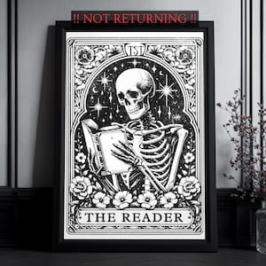 Könnte beinhalten: Ein schwarz-weißer gerahmter Druck, der ein Skelett zeigt, das in einem verzierten Torbogen ein Buch liest. Das Design enthält florale Akzente, Sterne sowie den Text TST oben und THE READER unten, alles in einem dekorativen Rahmen.