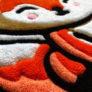 Detail of handmade tufted rug featuring red fox ears and plush texture – cozy kids decor