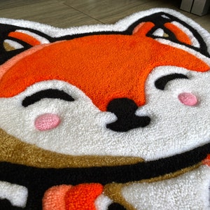 Close-up of tufted red fox rug showing soft handmade texture and vivid acrylic yarn