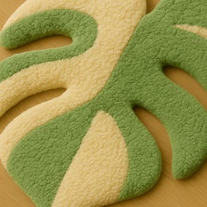 Minimalist tropical rug styled in entryway, variegated monstera leaf design.