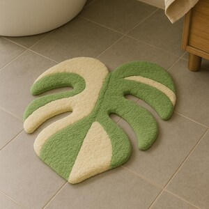 Tufted rug with two-tone monstera leaf shape used as bathroom mat.