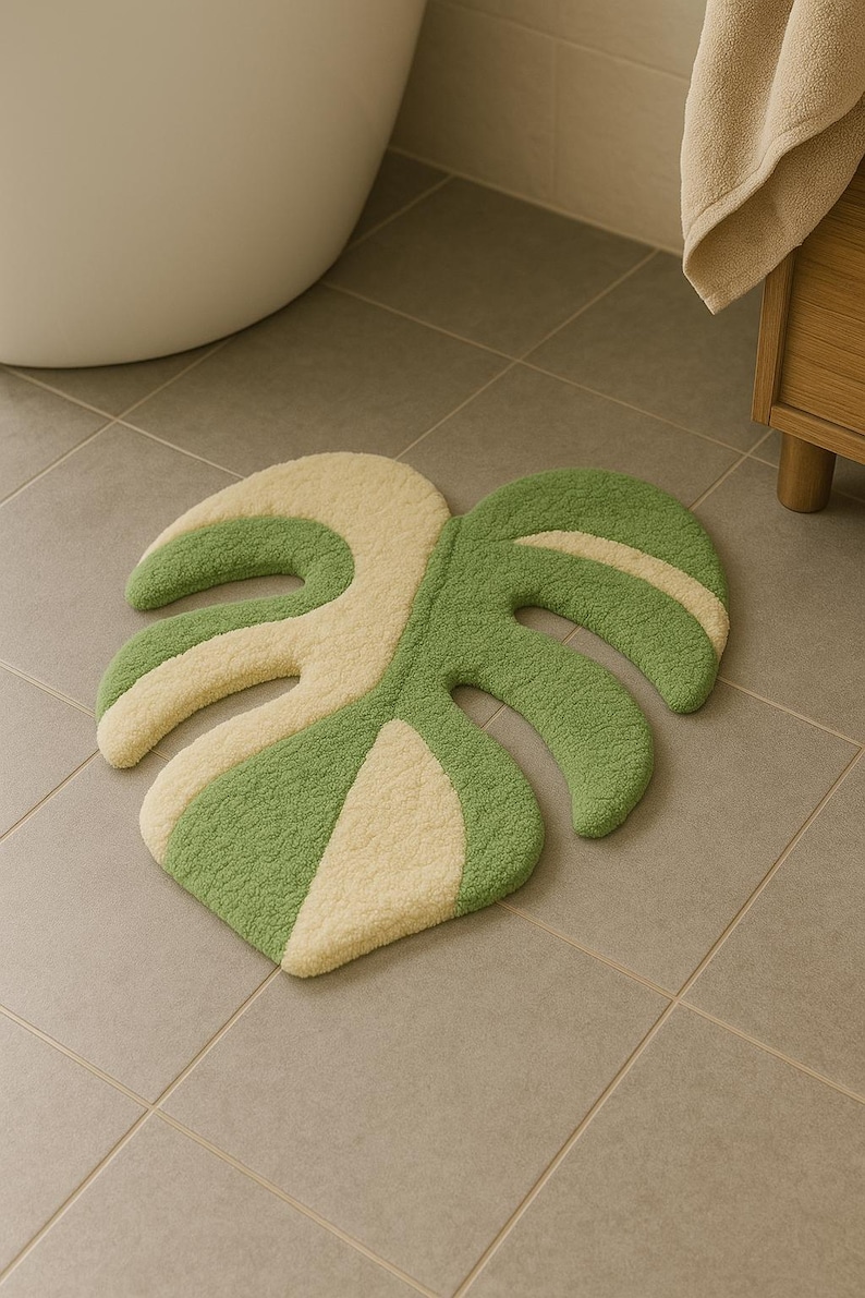 Tufted rug with two-tone monstera leaf shape used as bathroom mat.