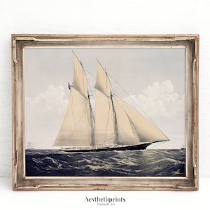 May include: A vintage illustration of a sailboat with white sails on a blue ocean. The sailboat is framed in a light brown wood frame.
