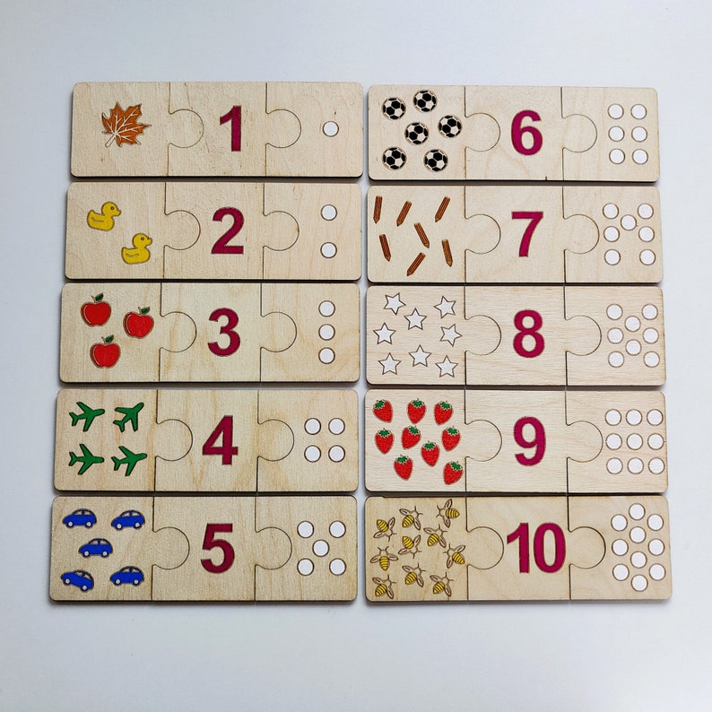 May include: Wooden puzzle pieces with numbers 1 through 10, each with a corresponding image. The images include a leaf, a duck, an apple, an airplane, a car, a soccer ball, a stick, a star, a strawberry, and a bee.