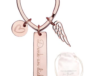 Peut inclure: Porte-clés en or rose avec un fermoir en forme de cœur, un charm rond avec un cœur, un charm aile et un charm rectangulaire avec le texte "Denke an dich". Comprend un petit sac en tissu avec texte.